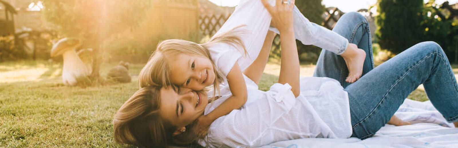 mom and daughter laying in grass