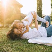 mom and daughter laying in grass