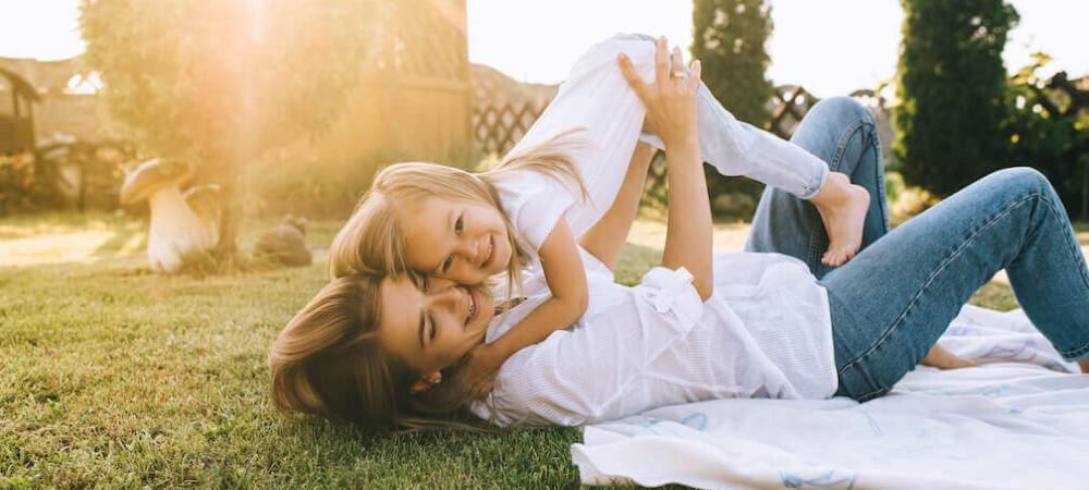 mom and daughter laying in grass